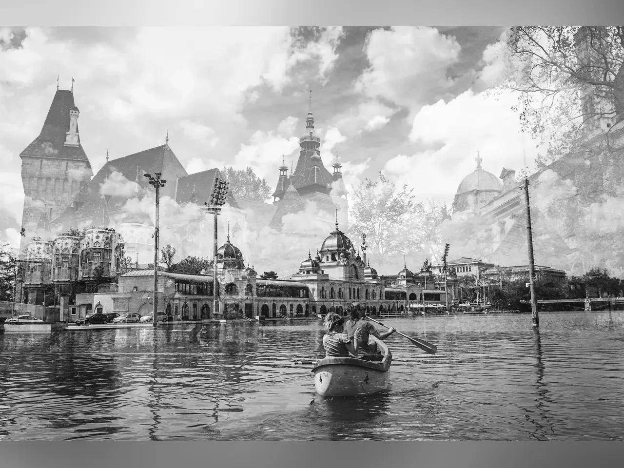 schwarz/weiß Fotografie mit Fluss und Boot im Vordergrund, Silhouette von Gebäuden im Hintergrund