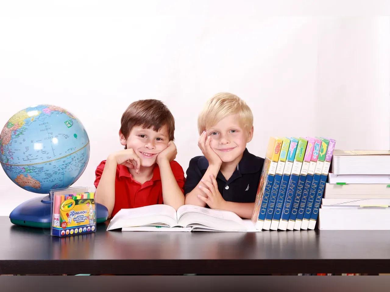 2 Jungs mit Büchern und einem Globus 