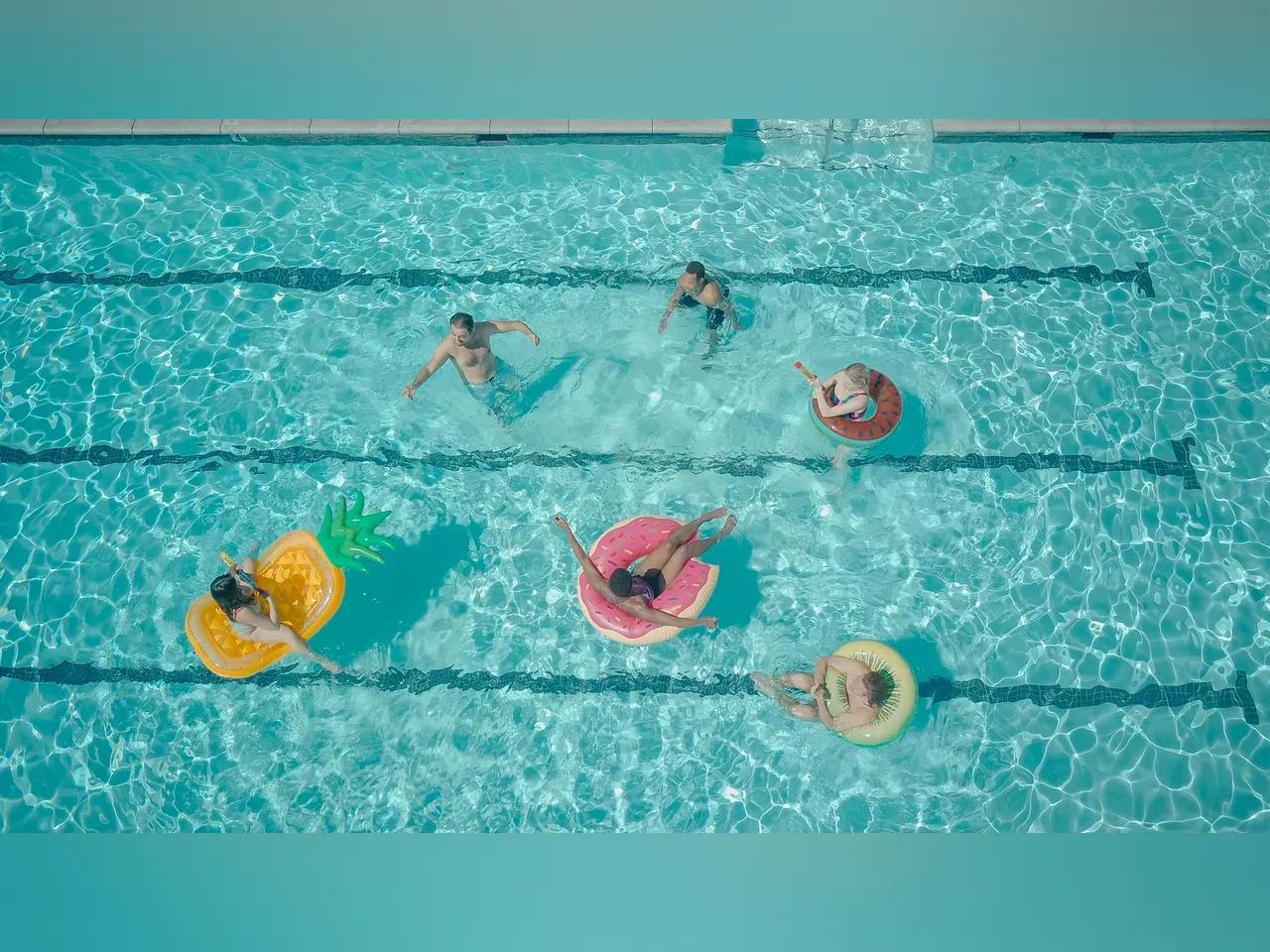 Pool von oben mit Menschen, die baden und auf großen Luftmatratzen liegen