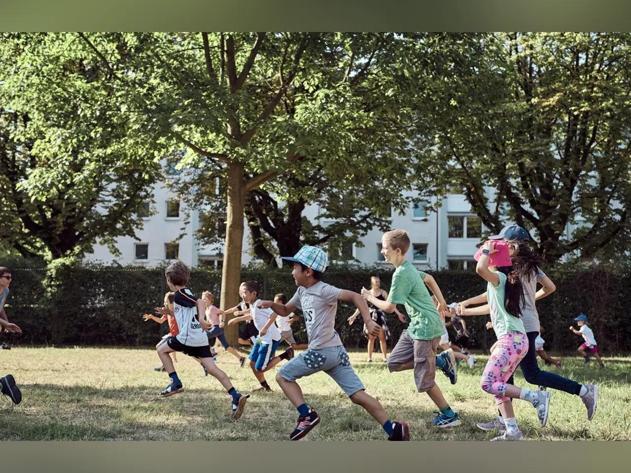 Kinder rennen fröhlich über eine Wiese