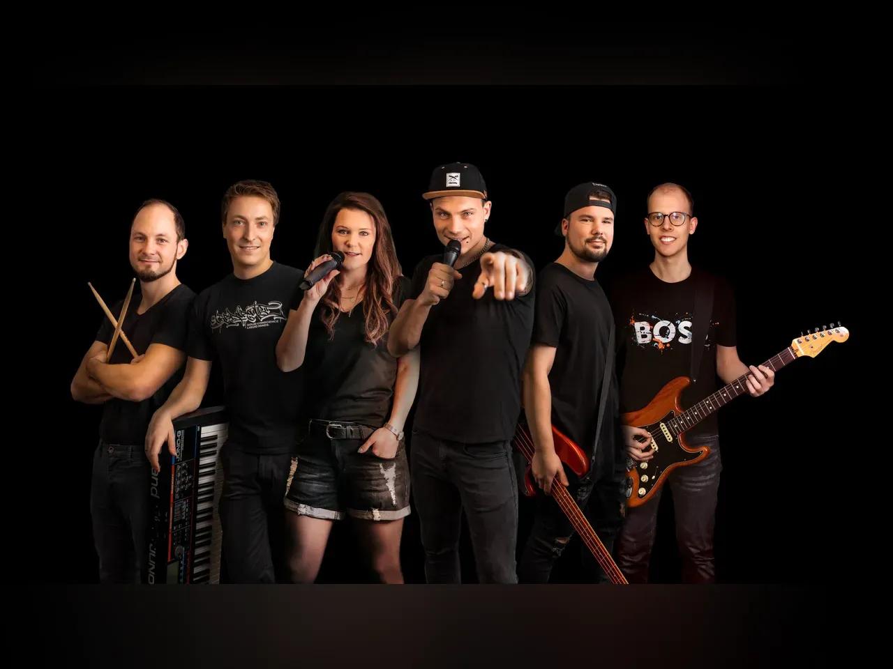 Die 6 Musiker:innen vor schwarzem Hintergrund