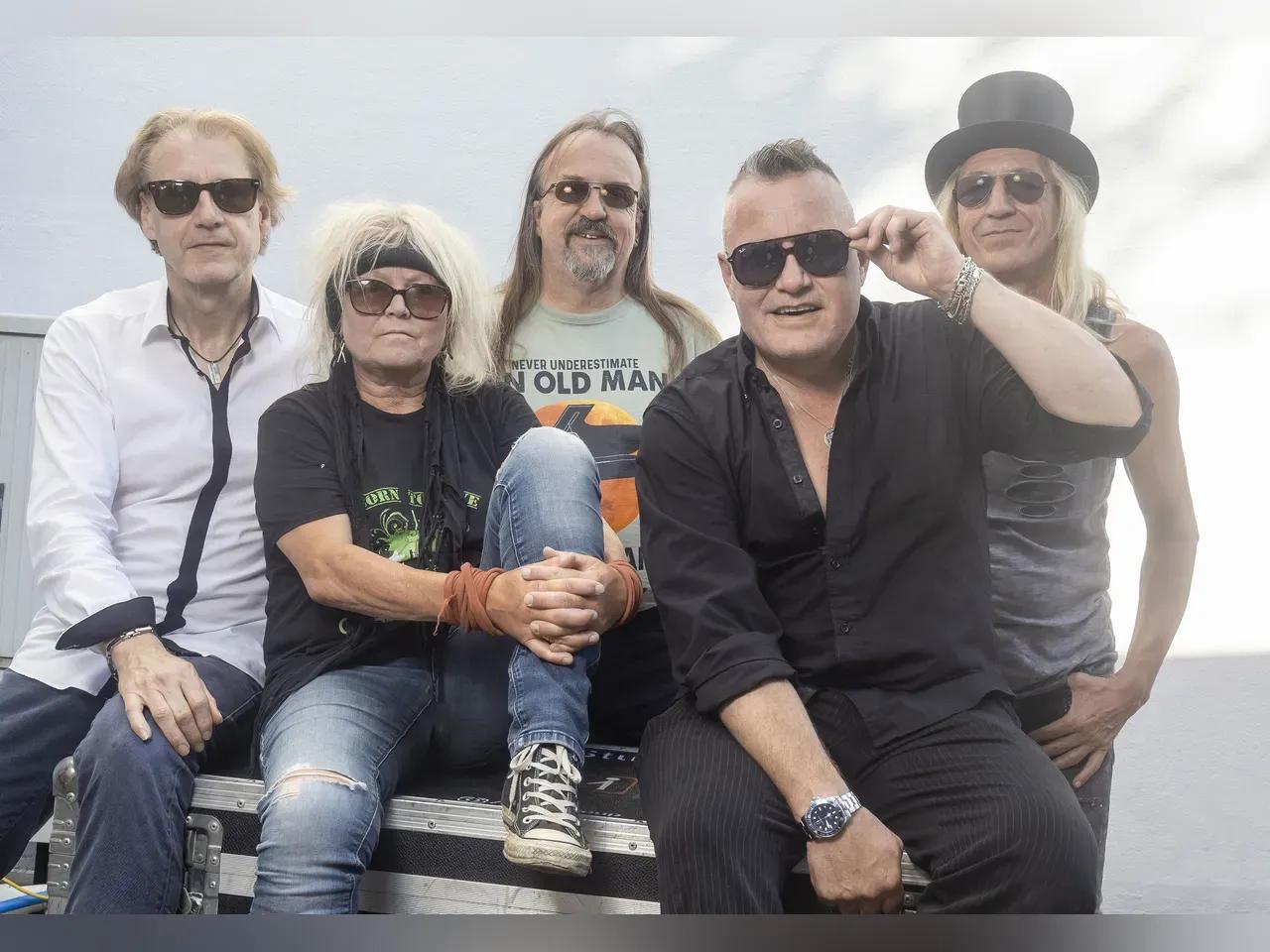 Vier Männer und eine Frau mit Bandana von den Crazy Birds, alle mit Sonnenbrillen an einer Technikbox.