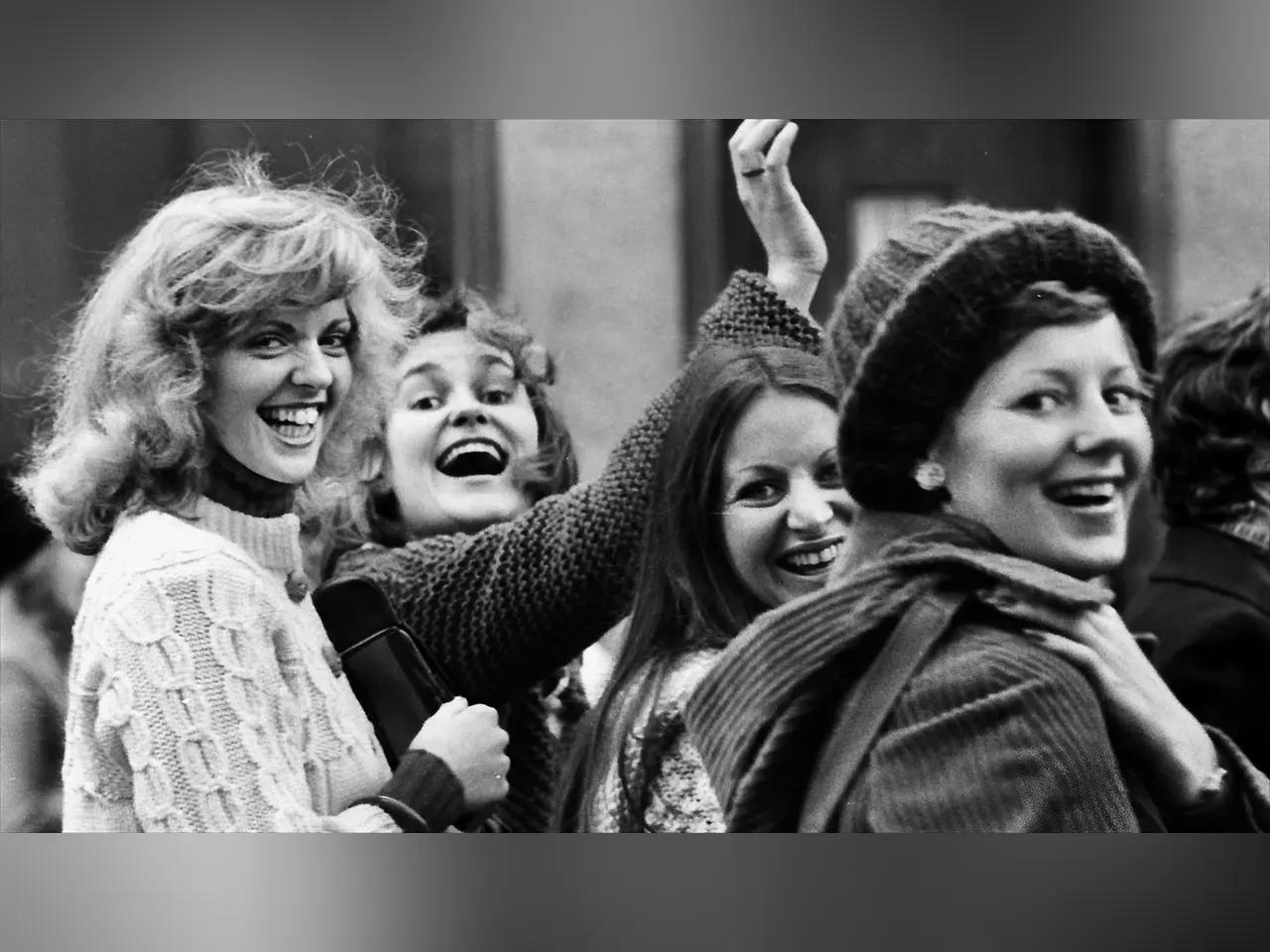 Schwarz-weiß Foto von lachenden Frauen auf der Straße