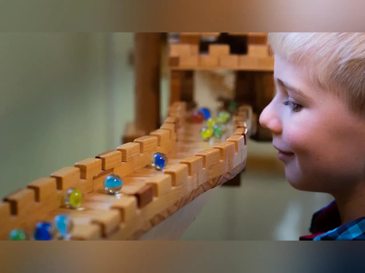 Ein Kind betrachtet eine Murmel im Murmiland