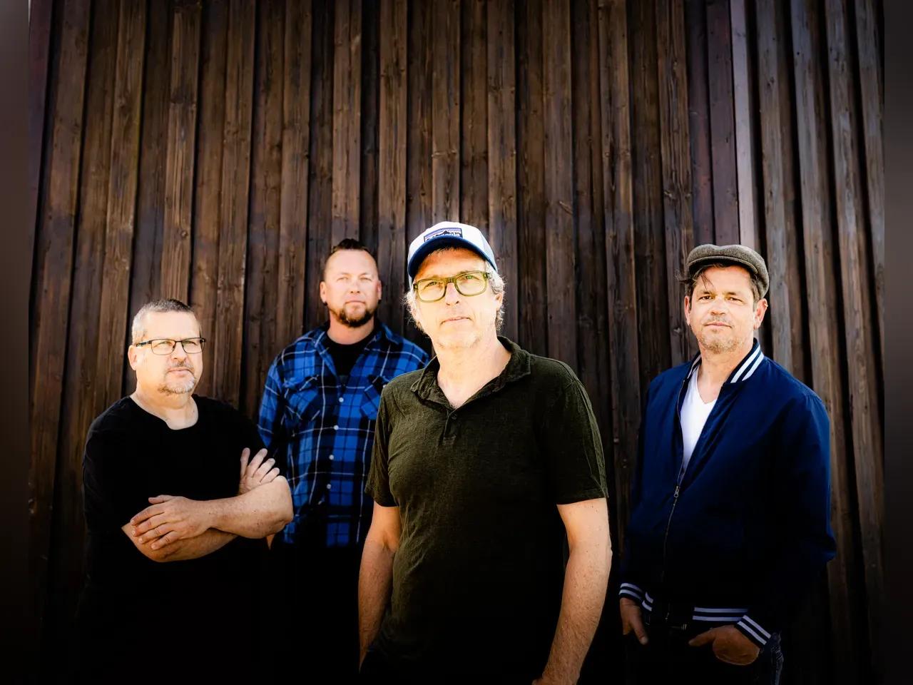 Die 4 Musiker der Band Dritte Wahl vor einer Bretterwand