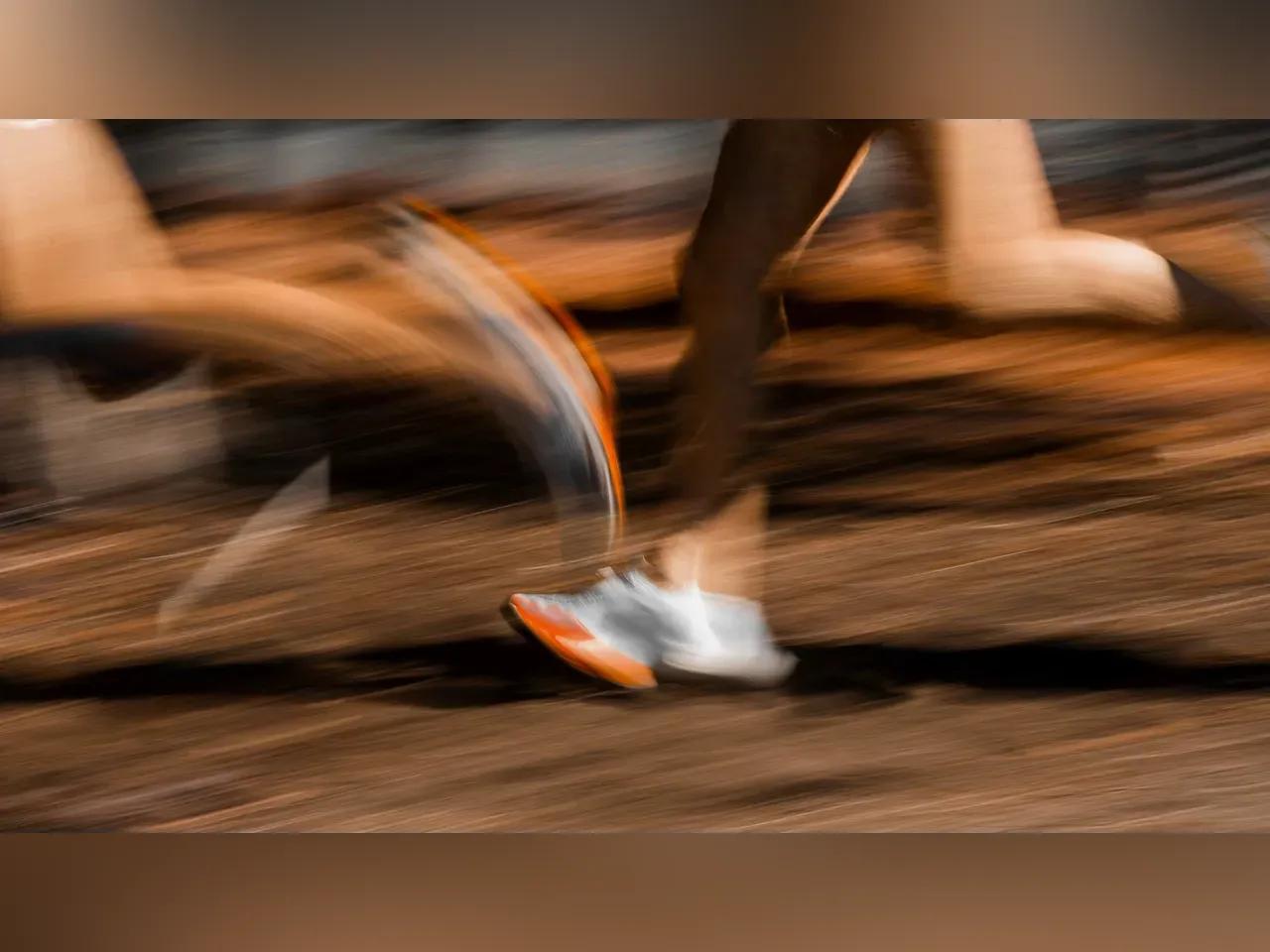 Beine von Läufern auf einer Strecke, die durch die Geschwindigkeit verschwimmen