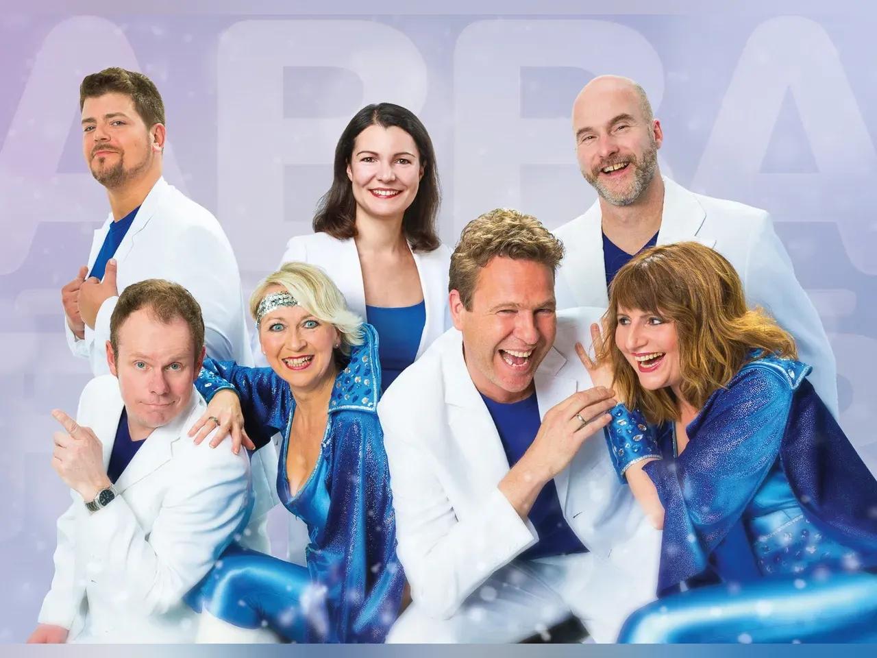 Mitglieder von AbbaFever in Disco Outfits und Arztkitteln