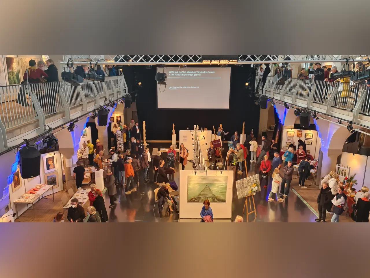 Saal des Volksbad Jena mit Kunstwerken und Besucher:innen