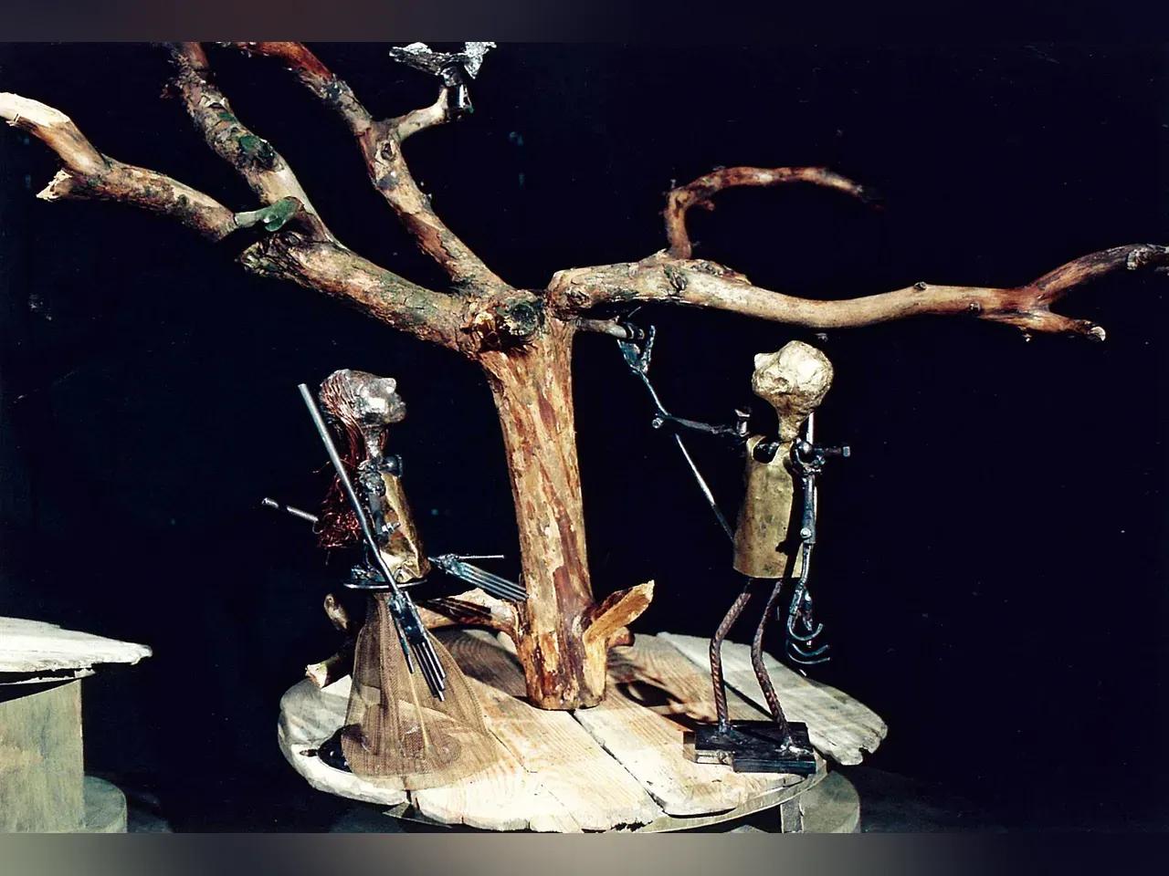 Metallfiguren vor einem Baum