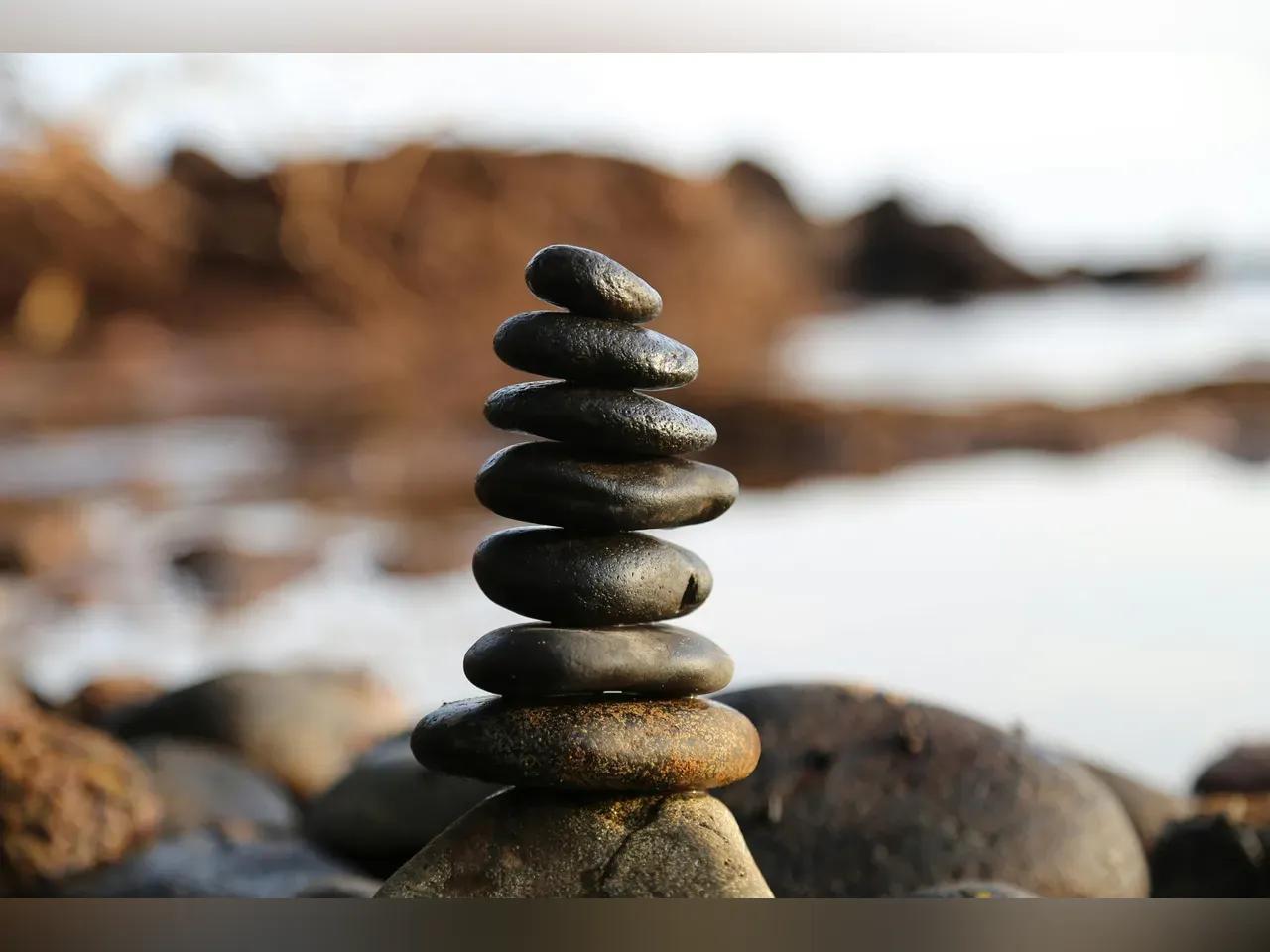 Ein Steinturm steht vor einer Meeresbucht.