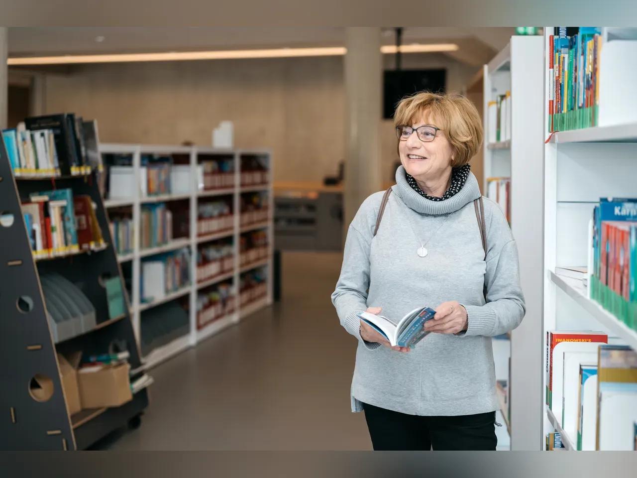 Ältere Frau in der Bücherei