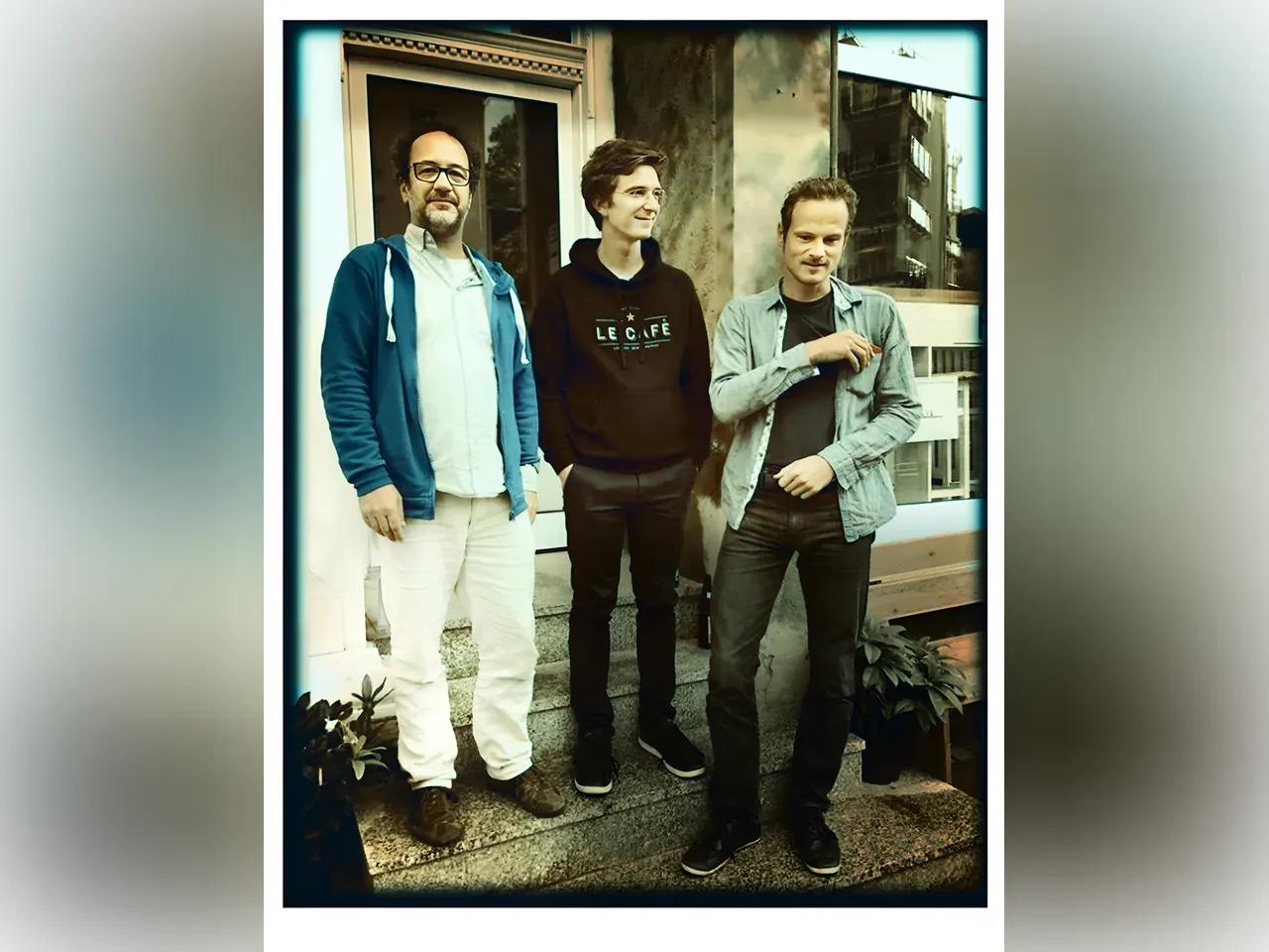 3 Musiker vor einem Haus