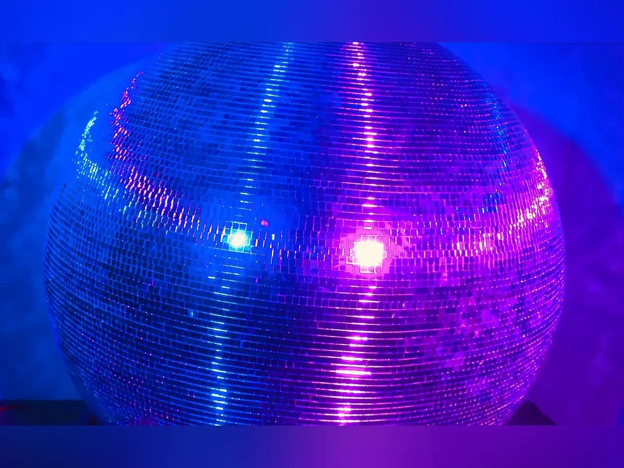 Nahaufnahme einer Diskokugel mit lilablauem Licht