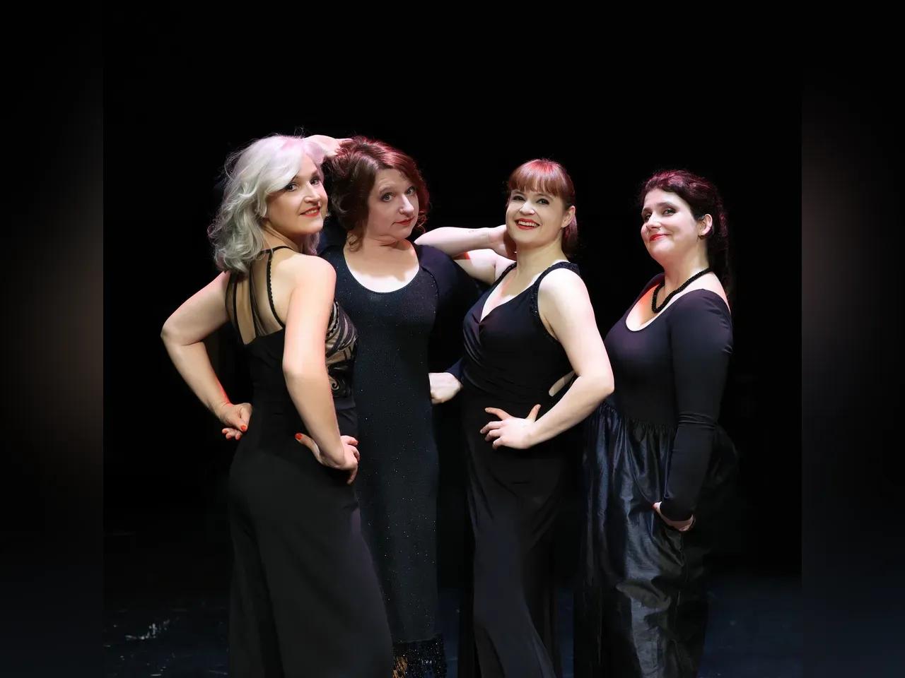 4 Sängerinnen in schwarzer Kleidung vor schwarzem Hintergrund