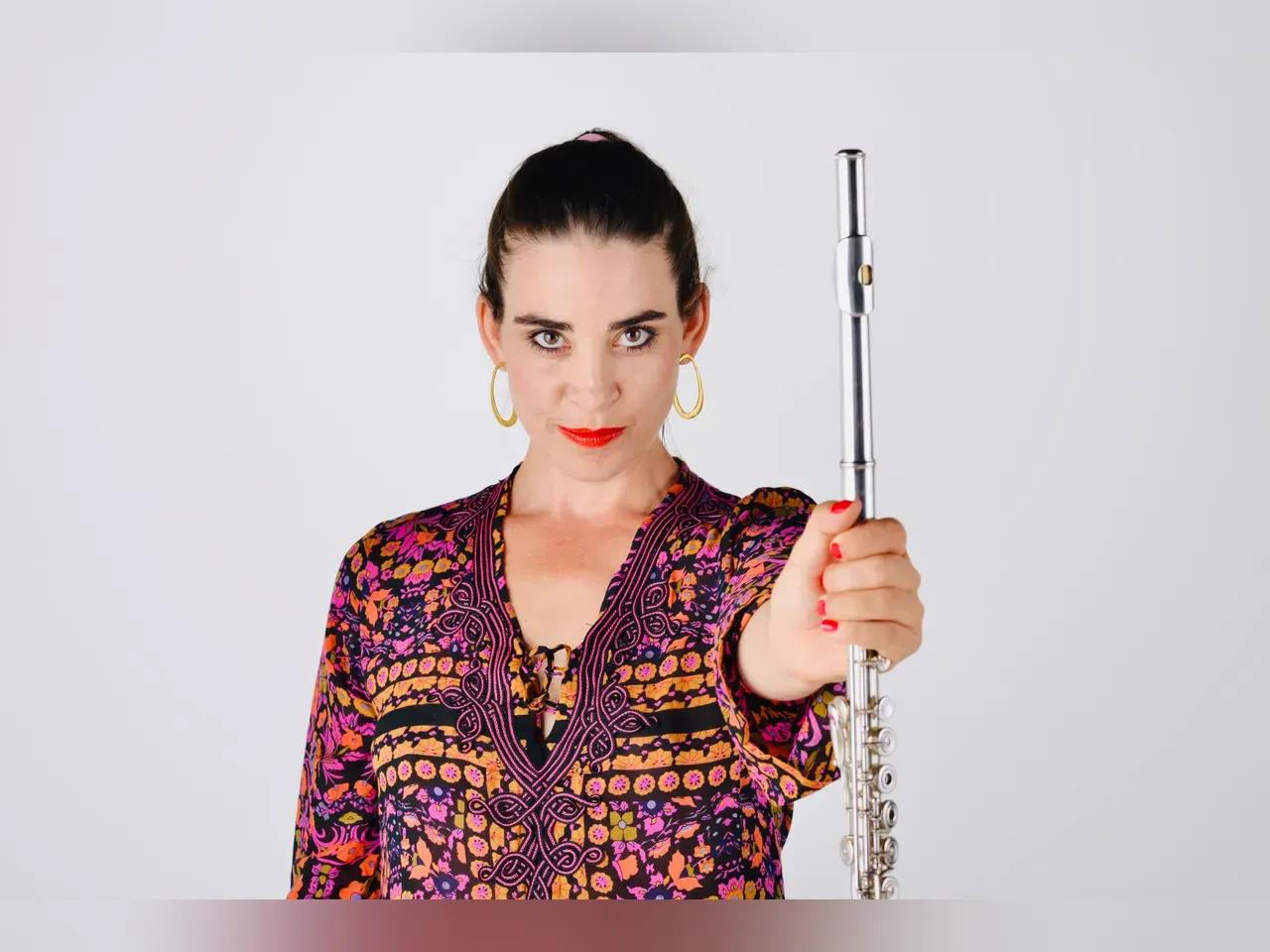 Frontalaufnahme von Ana de la Vega mit der Flöte in der ausgestreckten Hand