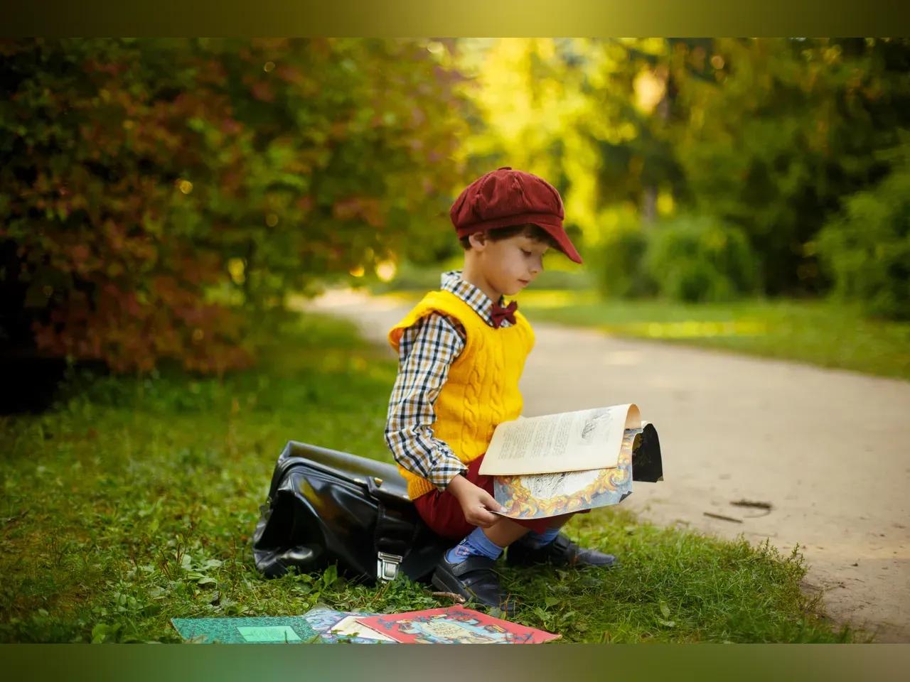 Junge sitzt am Wegesrand und ließt in einem Buch.