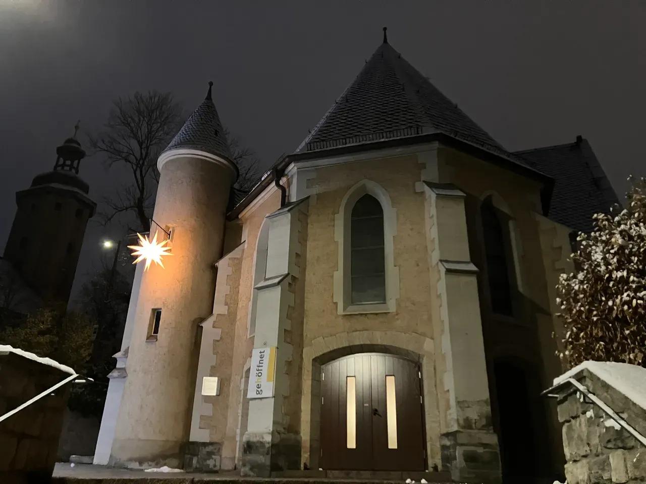 Eingang der Kirche St. Johannes Baptist in Jena mit Schnee und Herrnhuter Stern