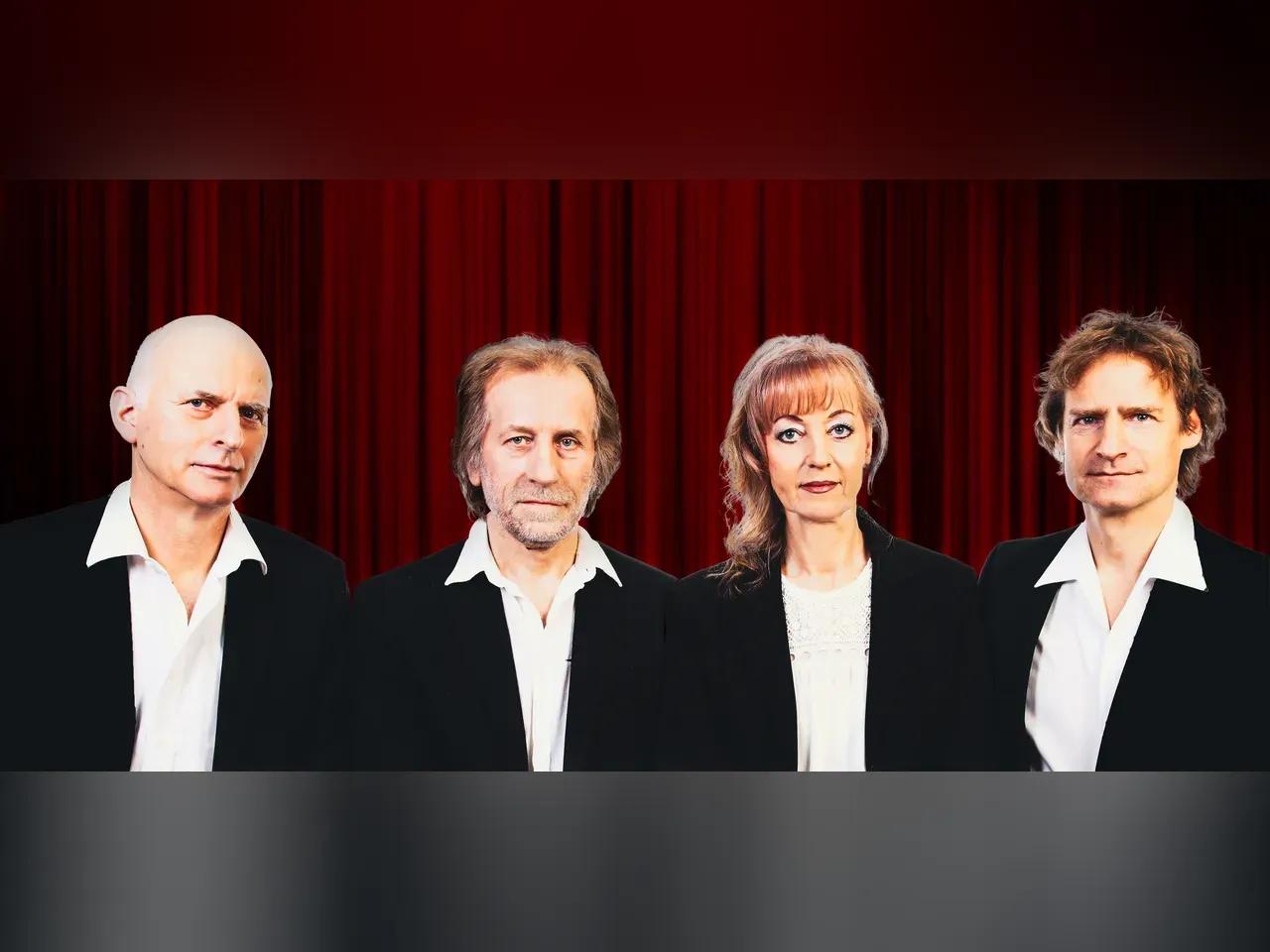 Musiker:innen von Soul Club in weißem Hemd und schwarzem Blaser vor einem roten Theatervorhang