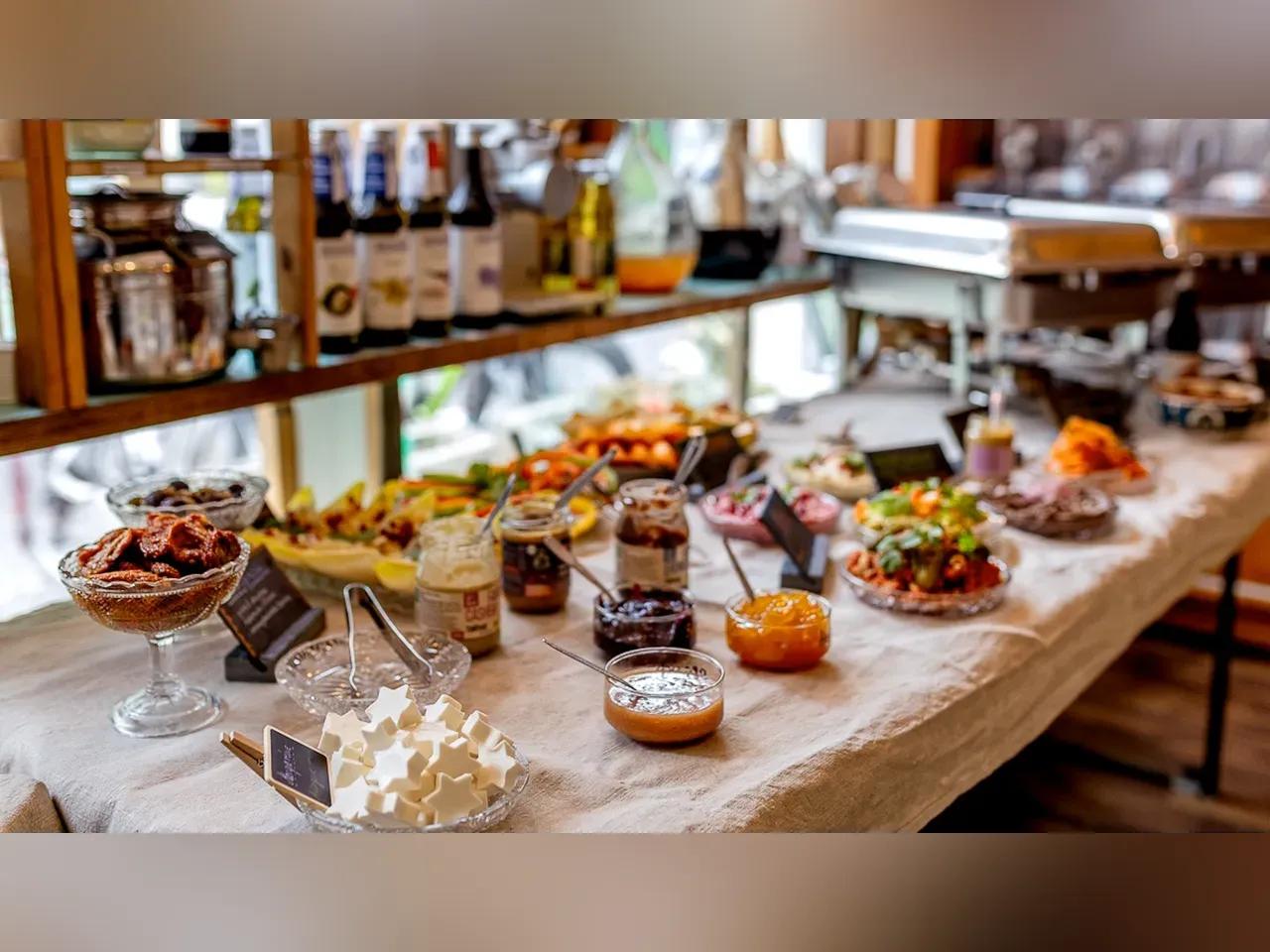 Brunch-Bufett mit Aufstrichen, Aufschnitten, Obst, Gemüse und Warmhaltebehältern