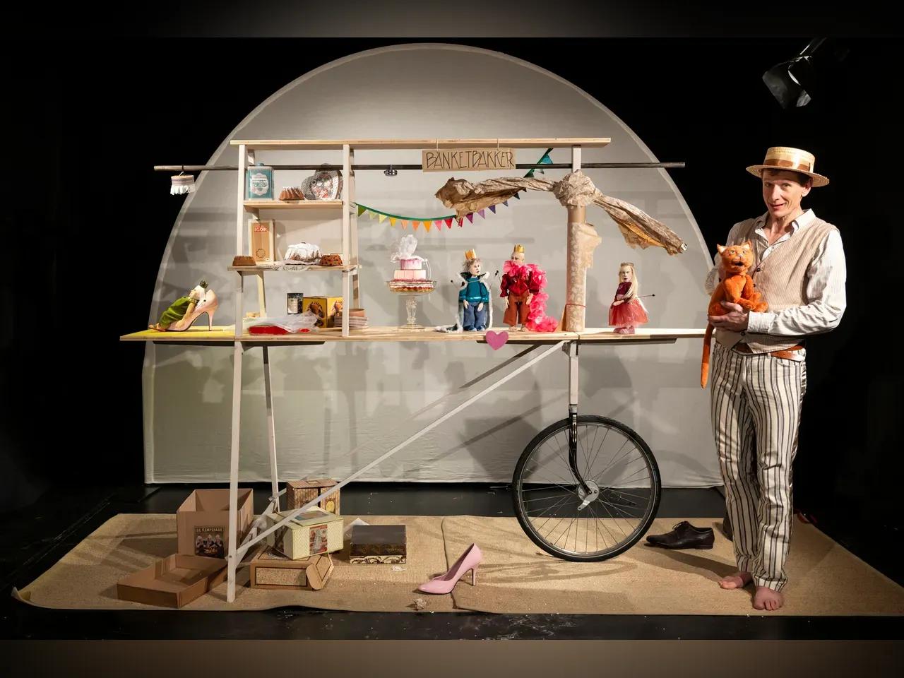 Puppenspieler steht neben den Requisiten des Stücks "König und König"