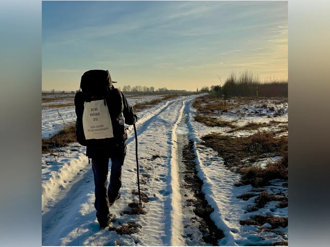 Wanderer auf einem schneebedeckten Feldweg