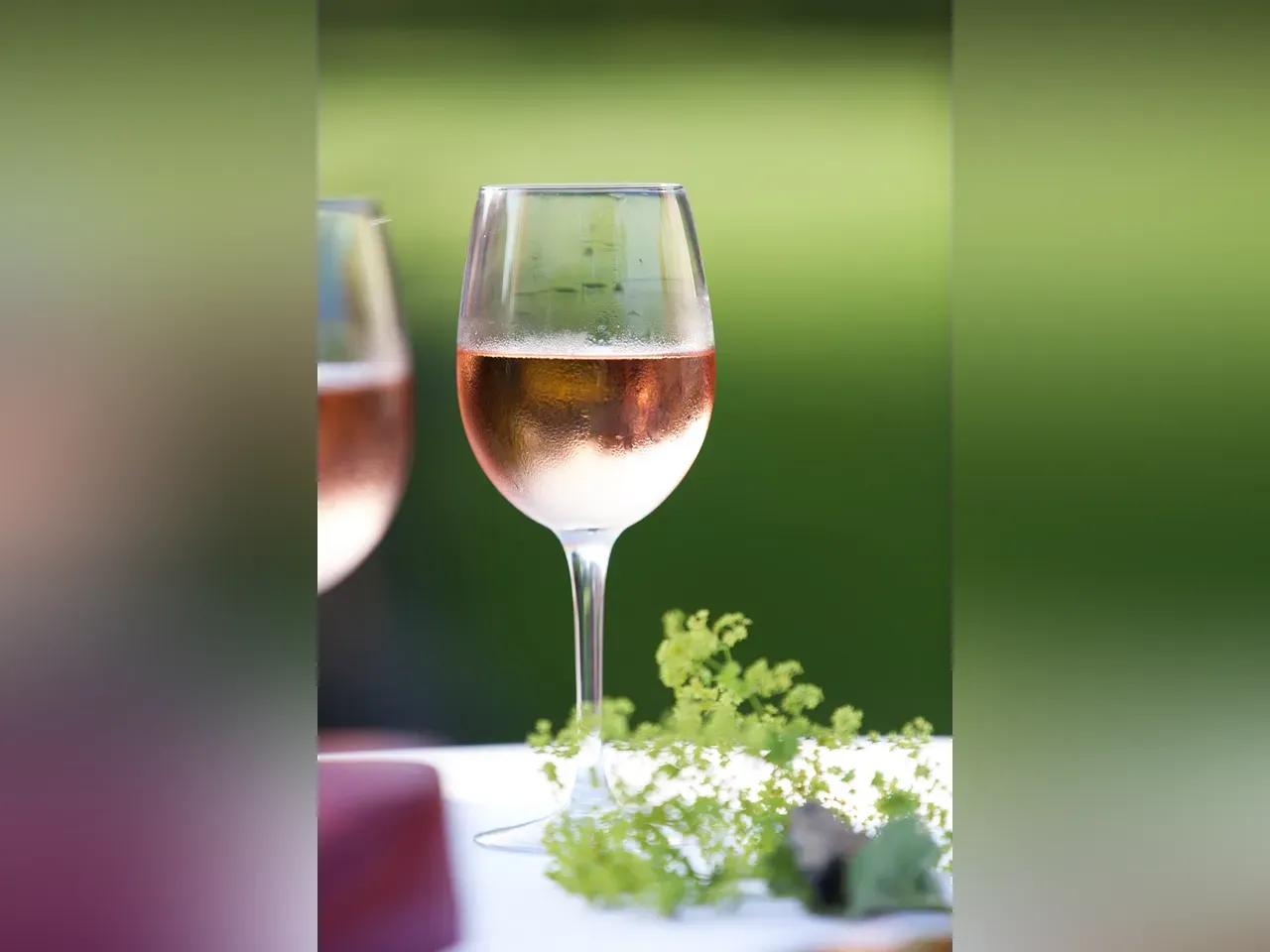 Zwei Gläser Roséwein auf einem im freien gedeckten Tisch