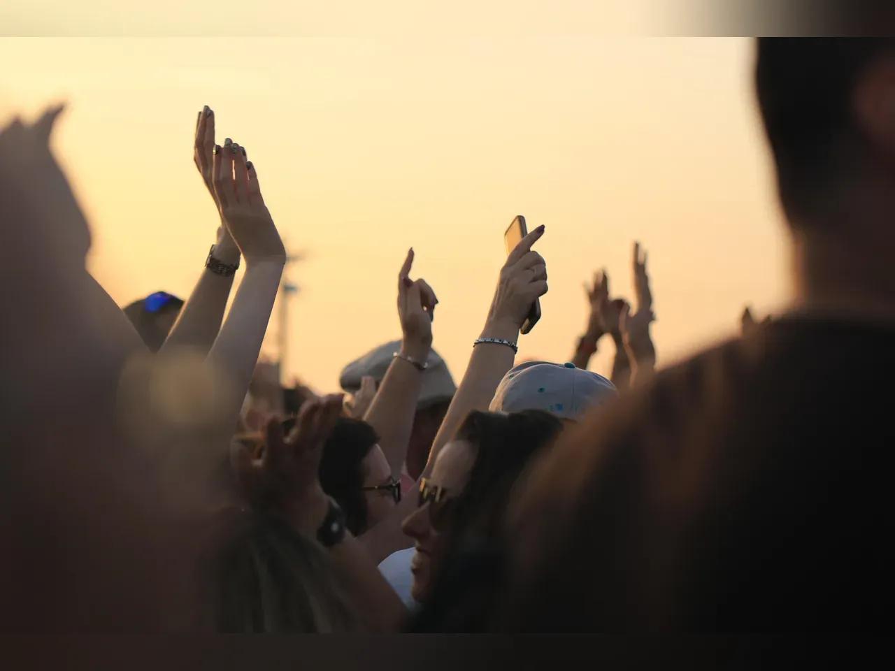 Menschenmenge, die beim Feiern die Hände in die Luft streckt