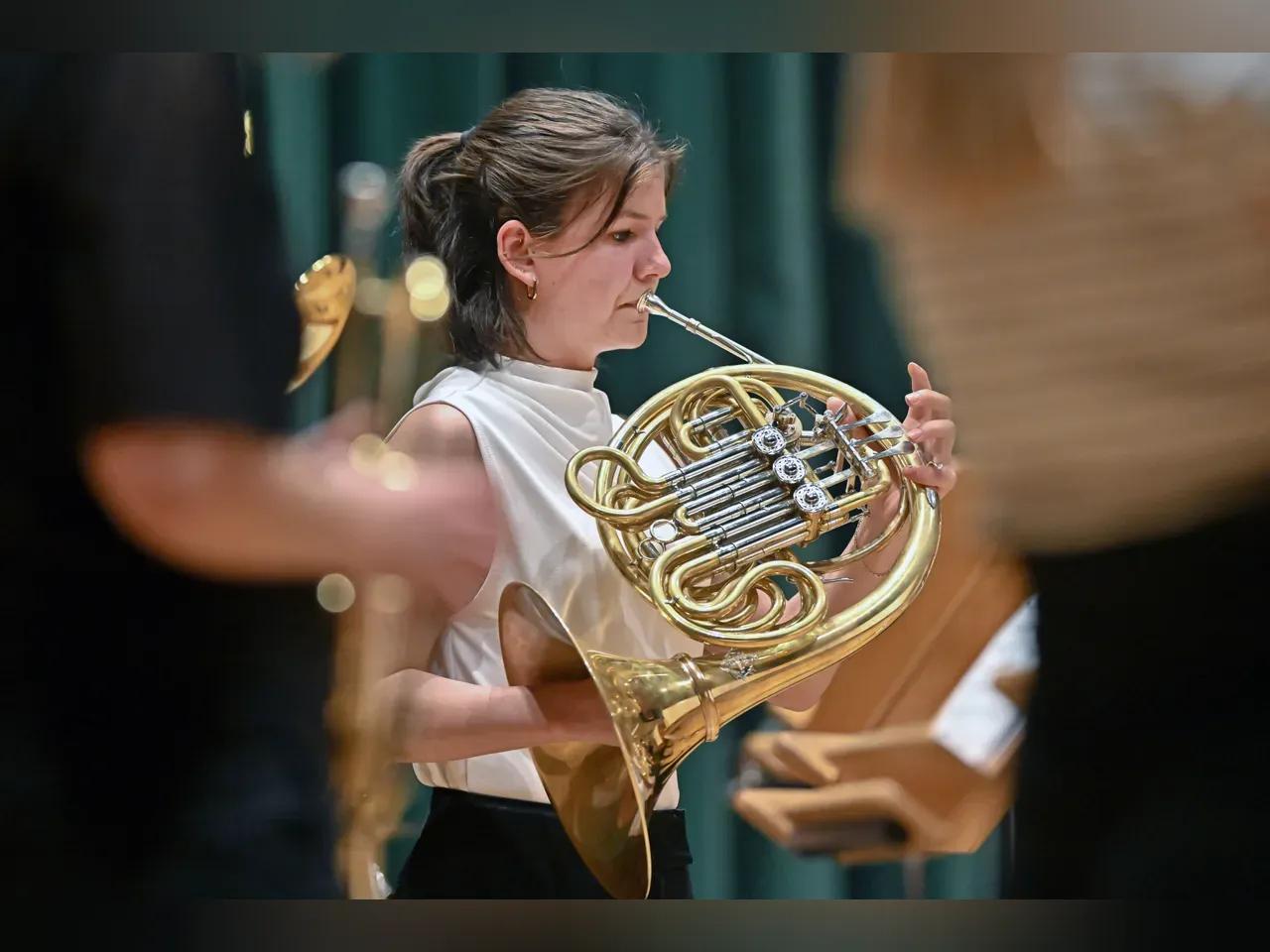 Eine Musikerin in eleganter Kleidung spielt ein Blasinstrument