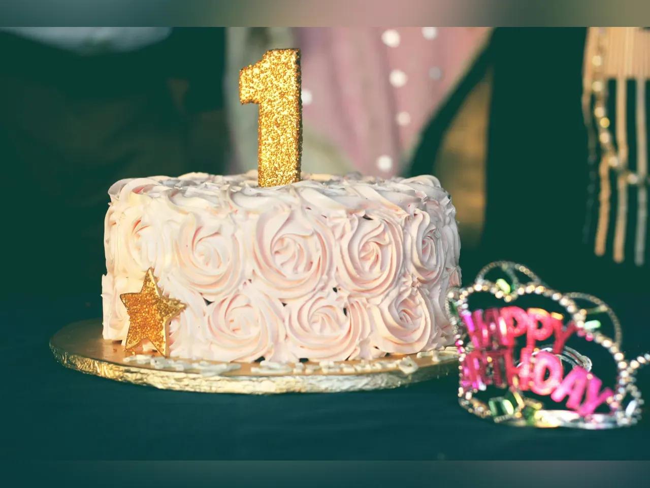 Bild einer schönen rosa Torte mit einer Kerze darauf in Form einer goldenen 1