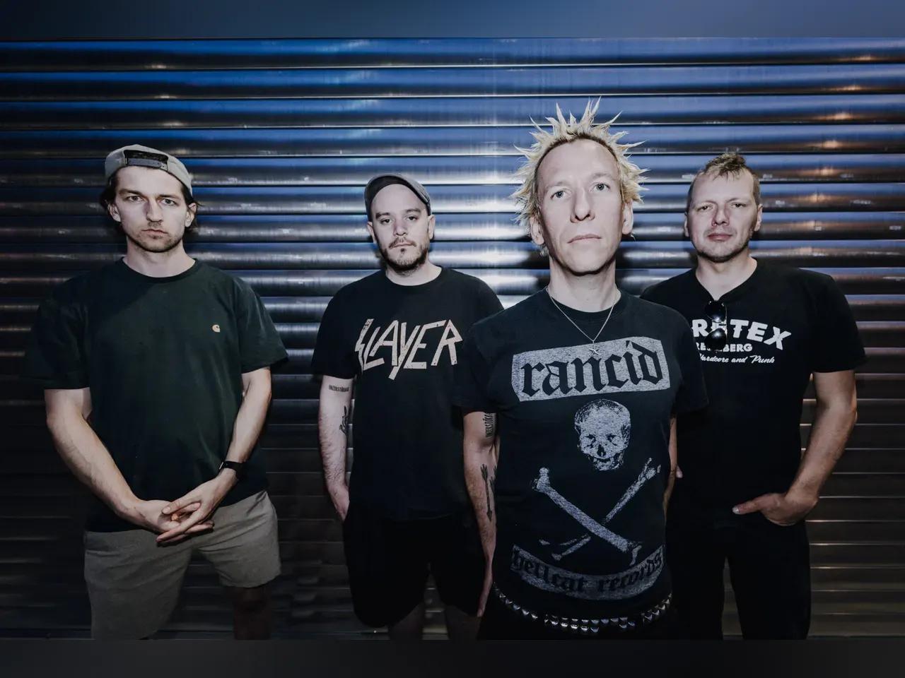 Bandmitglieder von ZSK stehen vor einem Rolltor