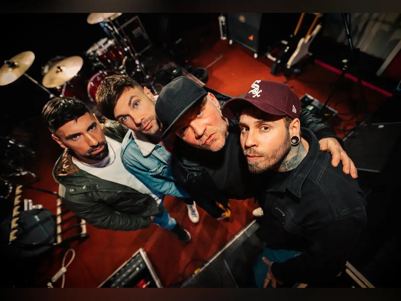 Bandmitglieder von Engst stehen nebeneinander in einem Proberaum und blicken nach oben in die Kamera