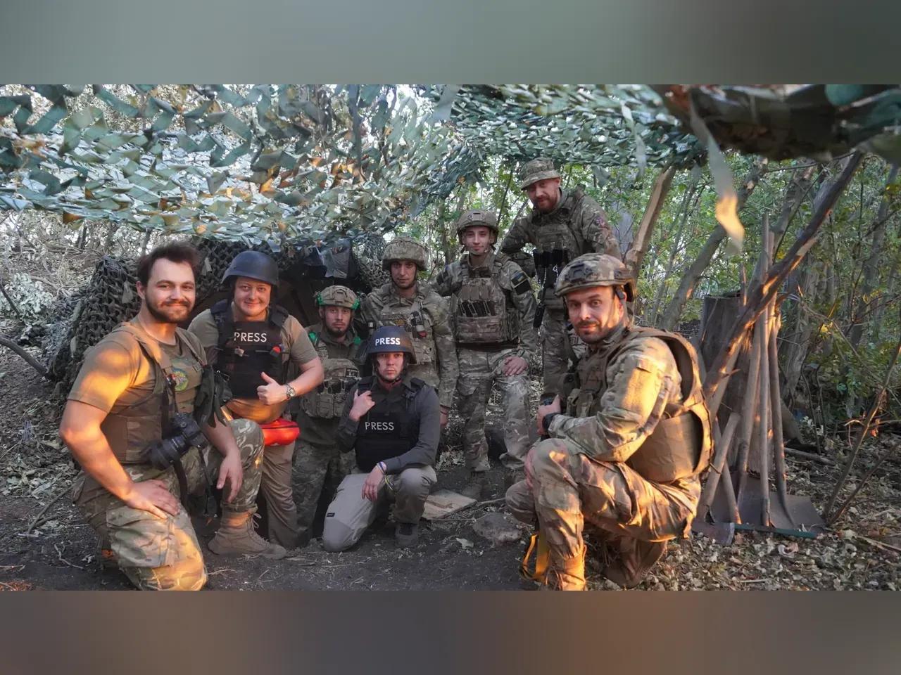 Kriegsreporter Jay J. C. Buckley mit Soldaten in einem Lager an der Front