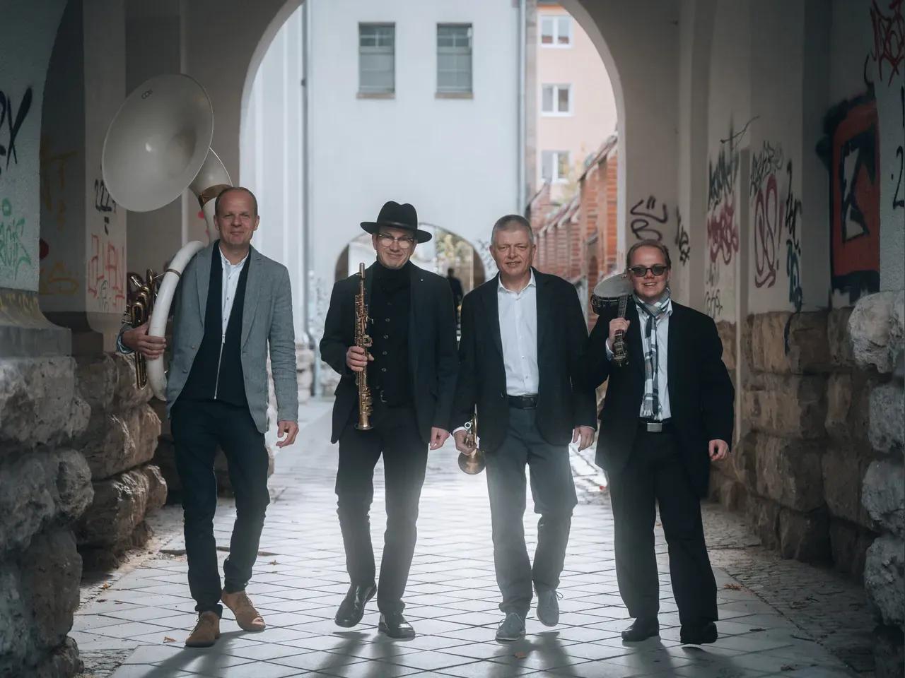 Vier Musiker nebeneinander in einem Durchgang