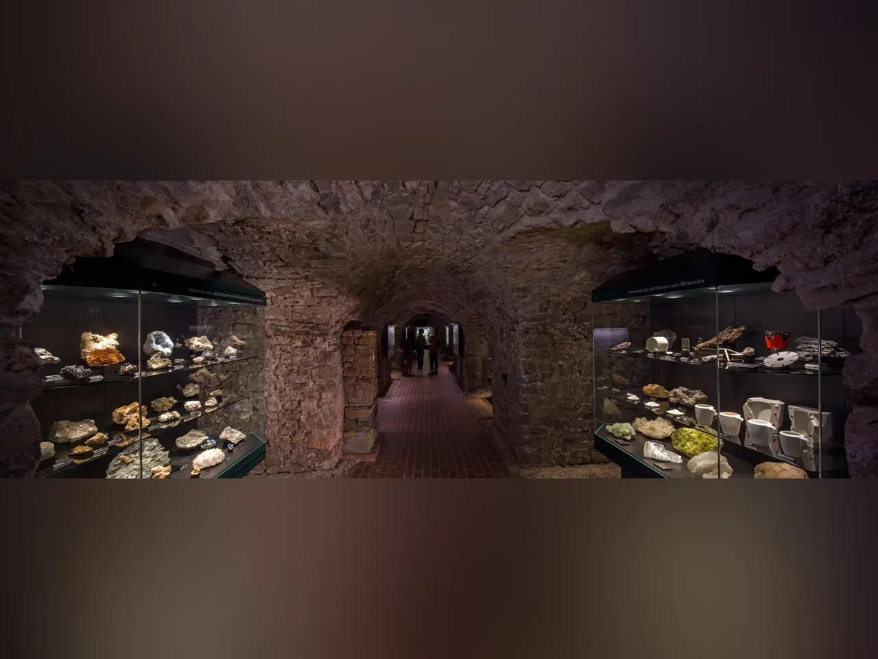 Tiefe Kellergewölbe (Höhler) mit Vitrinen links und rechts, darin Mineralien