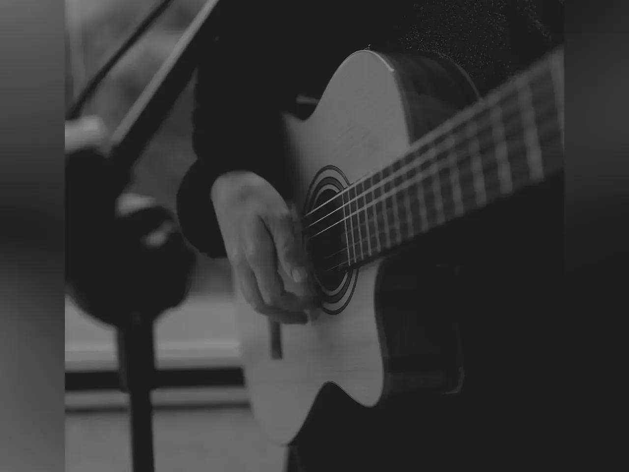 Nahaufnahme eines Menschen, der Gitarre spielt in schwarz-weiß