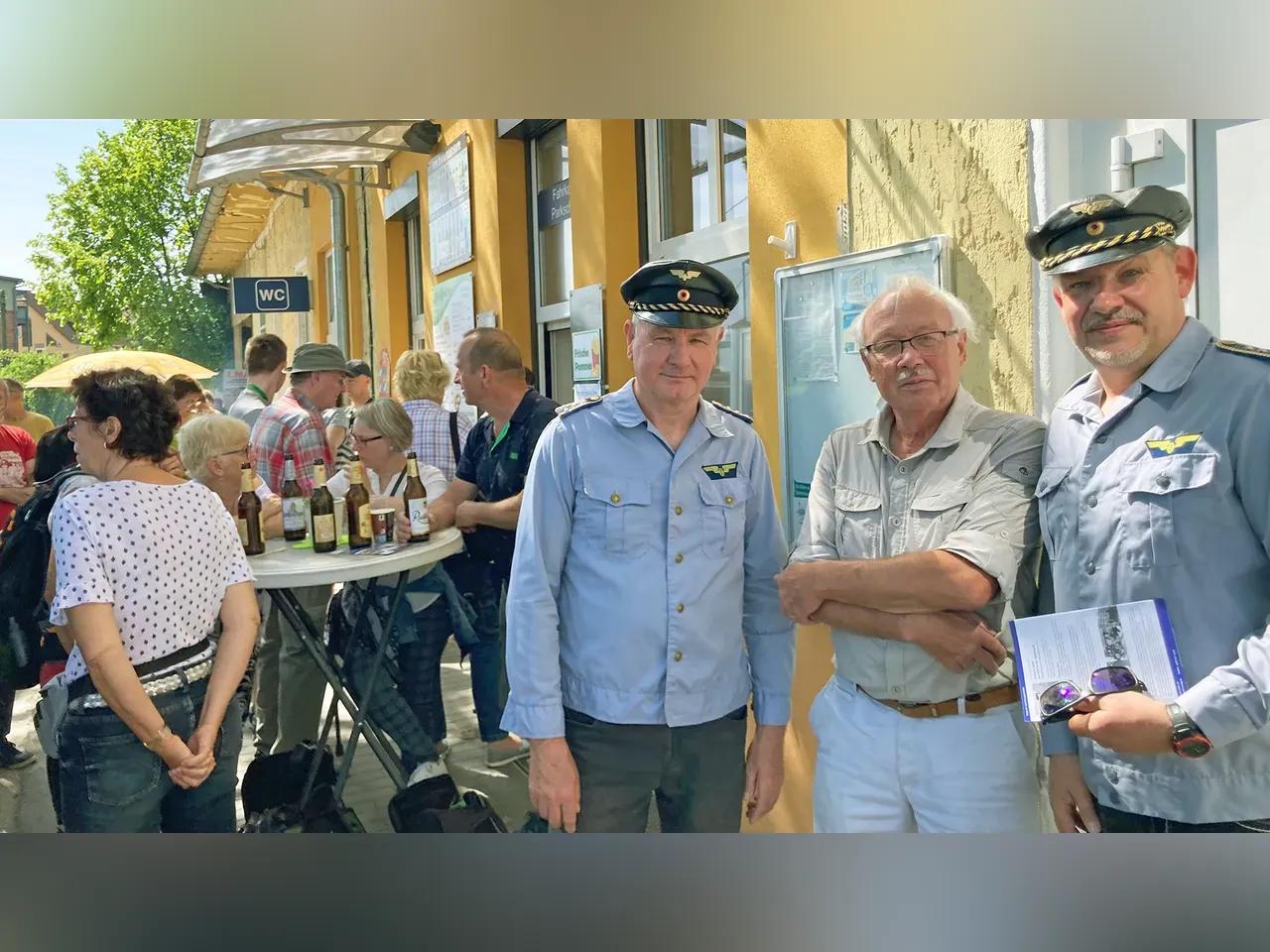 Mitarbeitende mit Schaffnermützen und Gäste vor der Bahnhofswirtschaft Gleis 3Viertel in Göschwitz