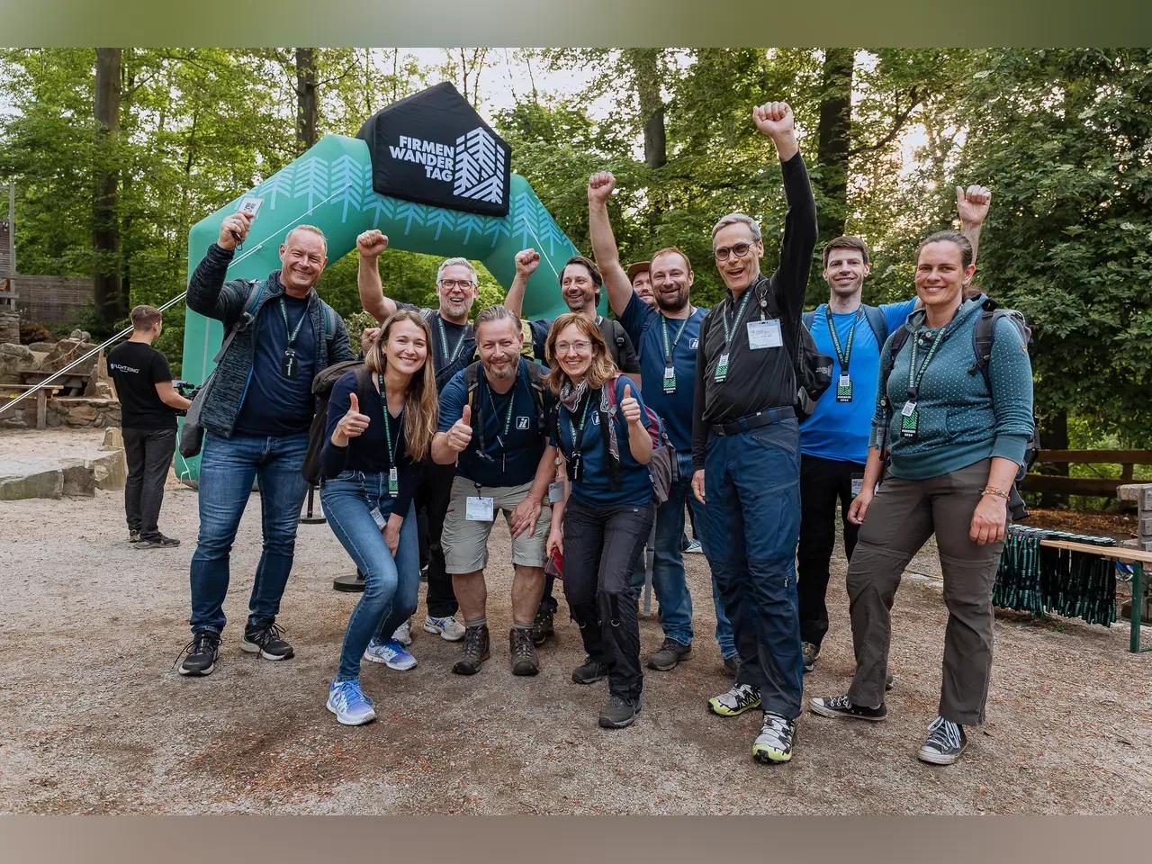 Gruppe Menschen, die fröhlich am Firmenwandertag teilnehmen
