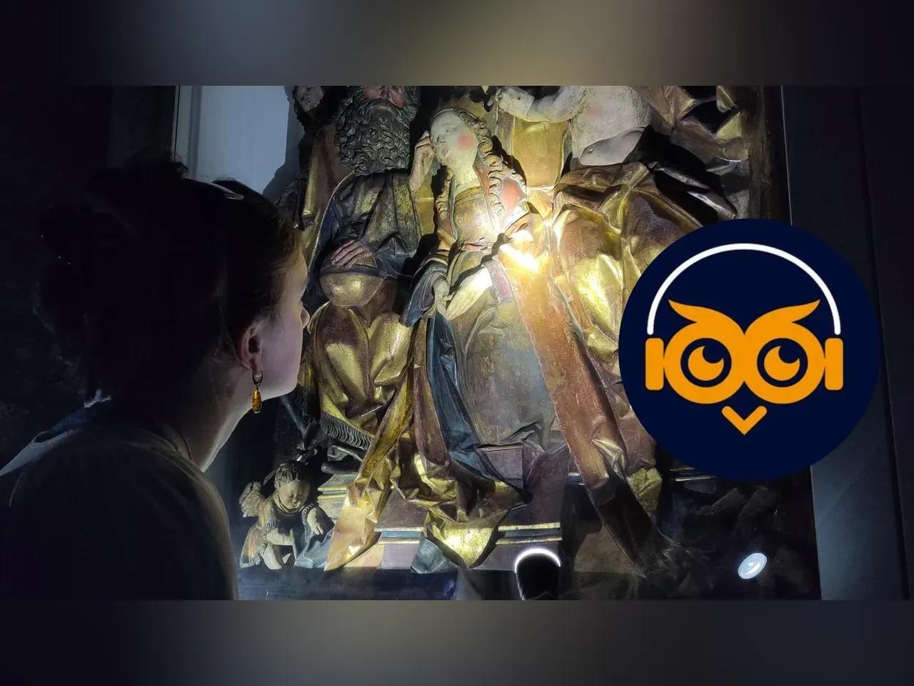 Frau von hinten, leuchtet mit einer Taschenlampe ein Altarbild von unten an