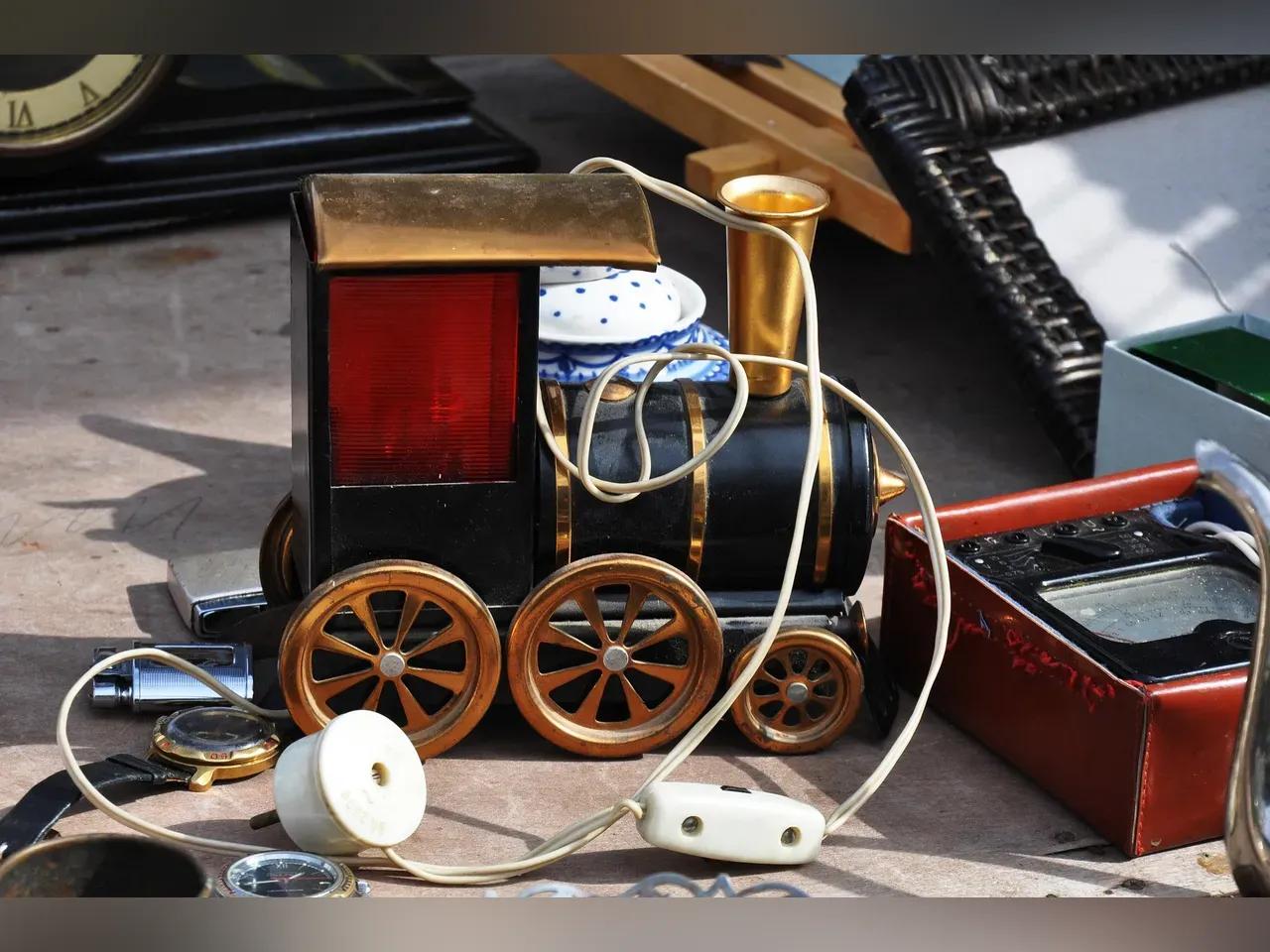 Flohmarktwaren, im Zentrum eine Lampe in Form einer Lokomotive