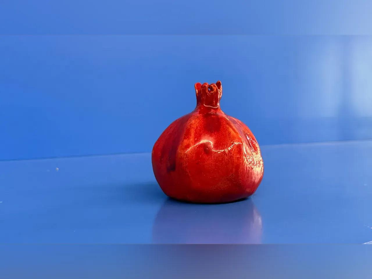 Roter Granatapfel vor blauem Hintergrund