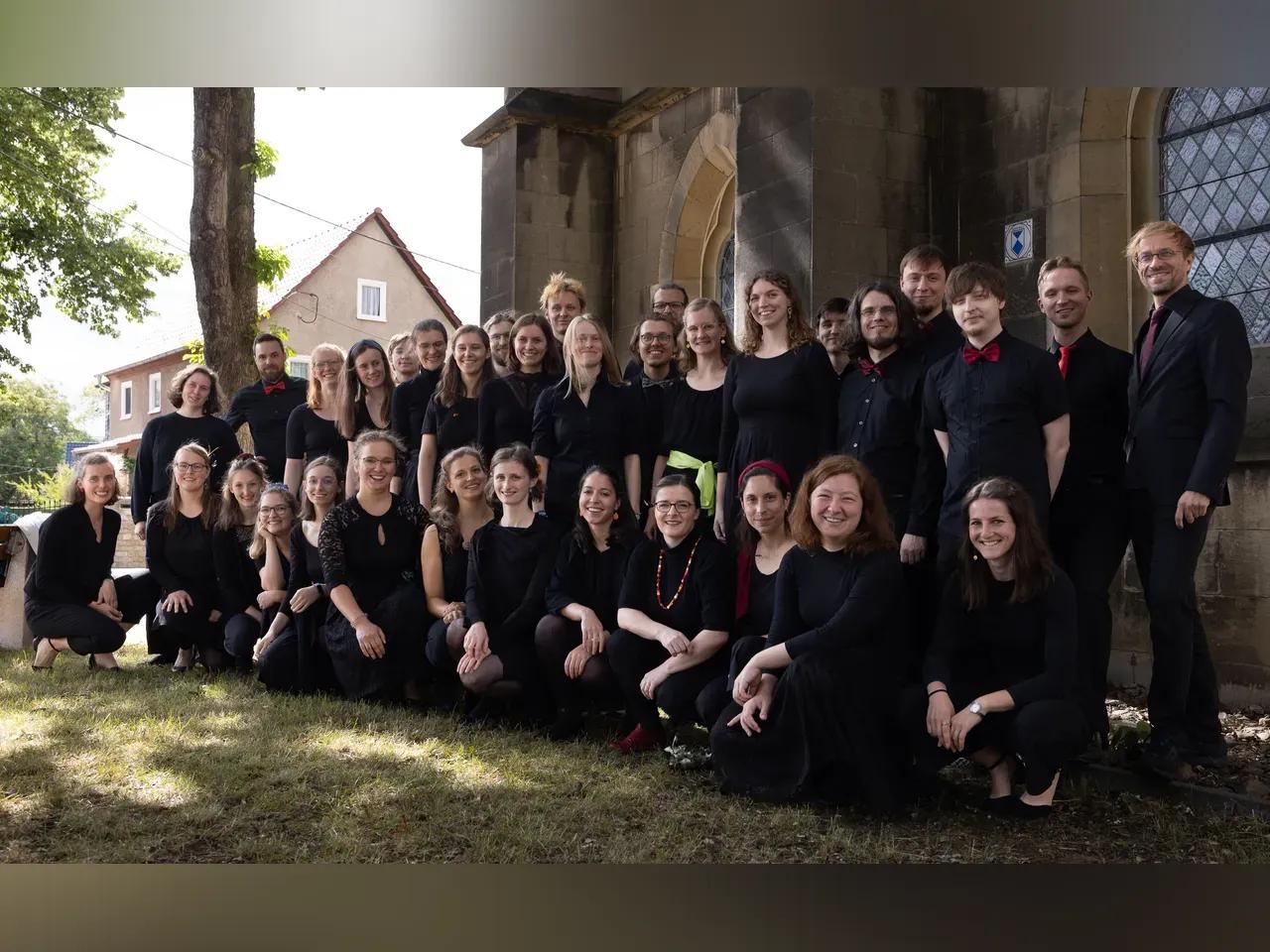Mitglieder des Chorissimo Jena vor einer Kirche aufgereiht