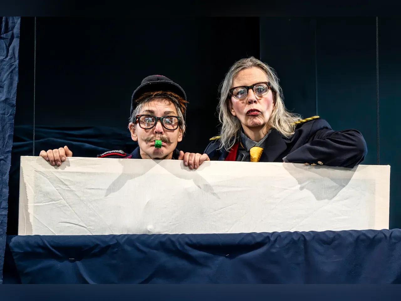 Zwei Schauspieler:innen in Kostümen