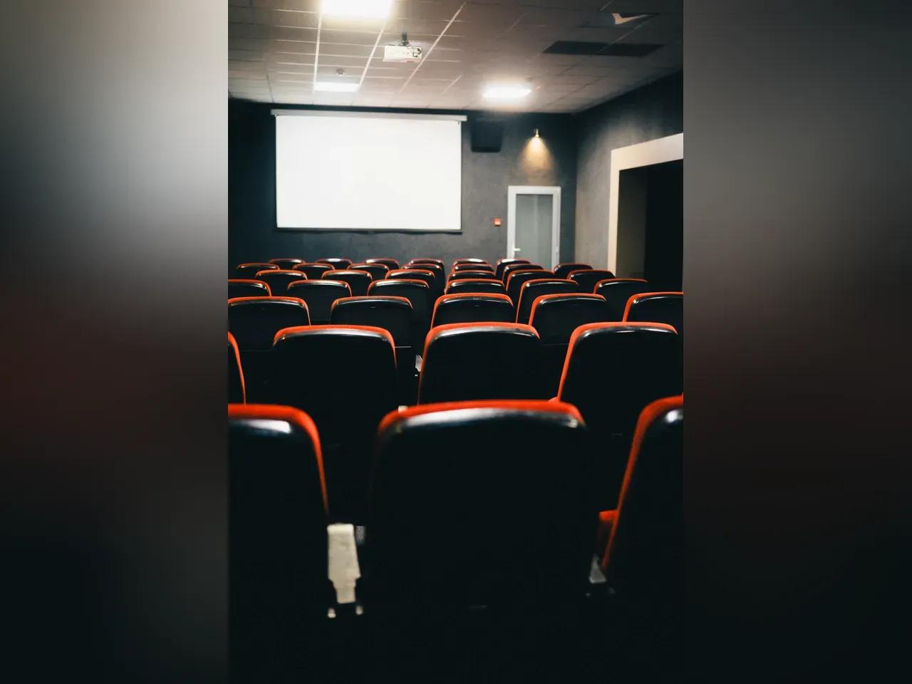 Kinosaal mit Leinwand und roten Sitzen