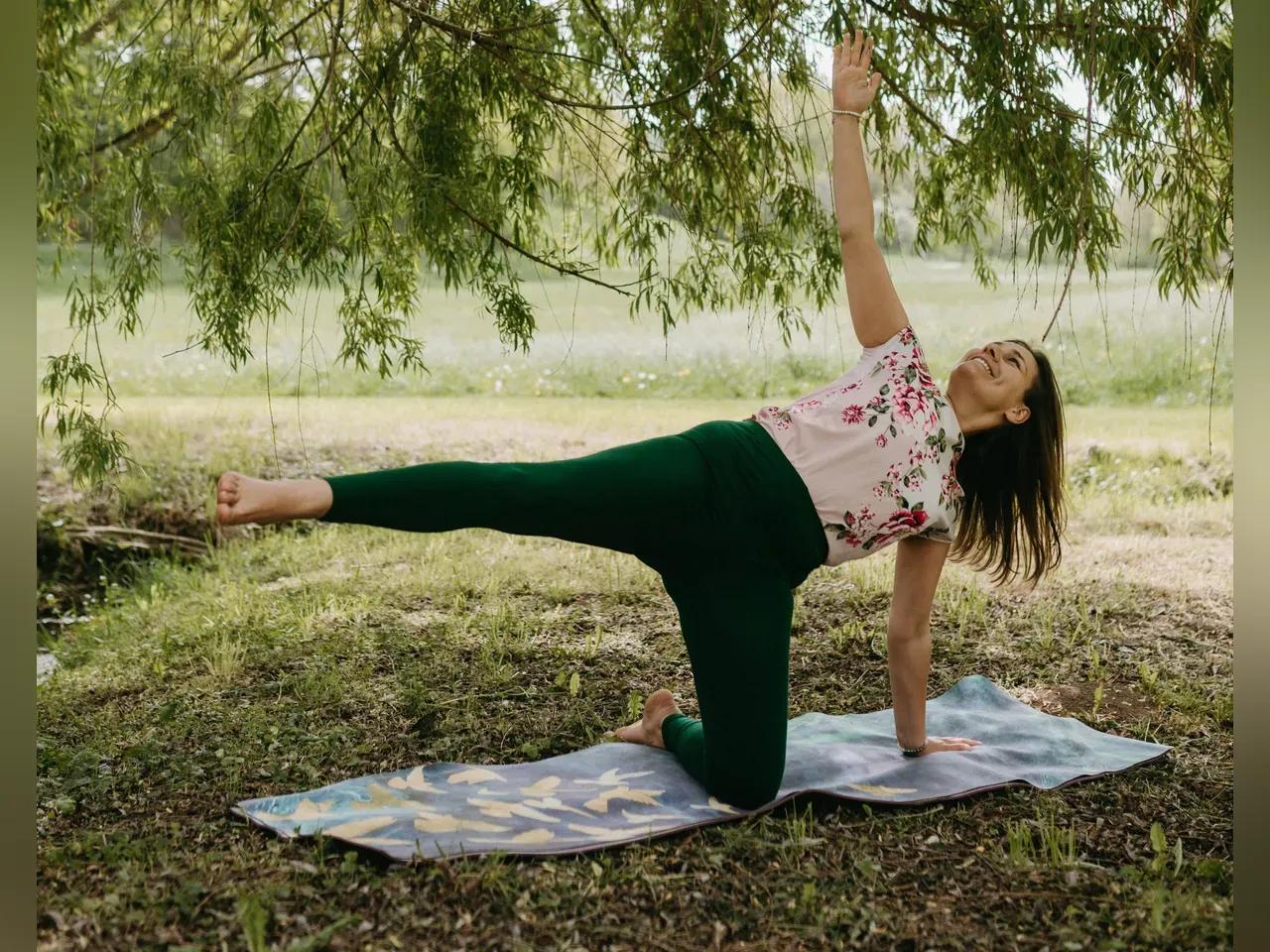 Eine Frau macht eine Yoga-Übung unter einem Baum