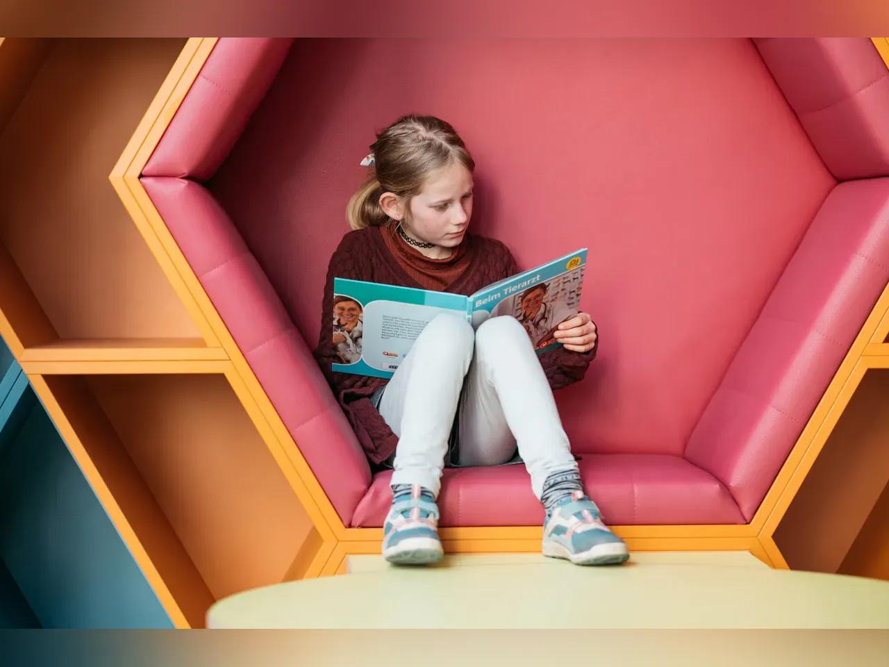 Mädchen mit blonden Haaren liest ein Buch