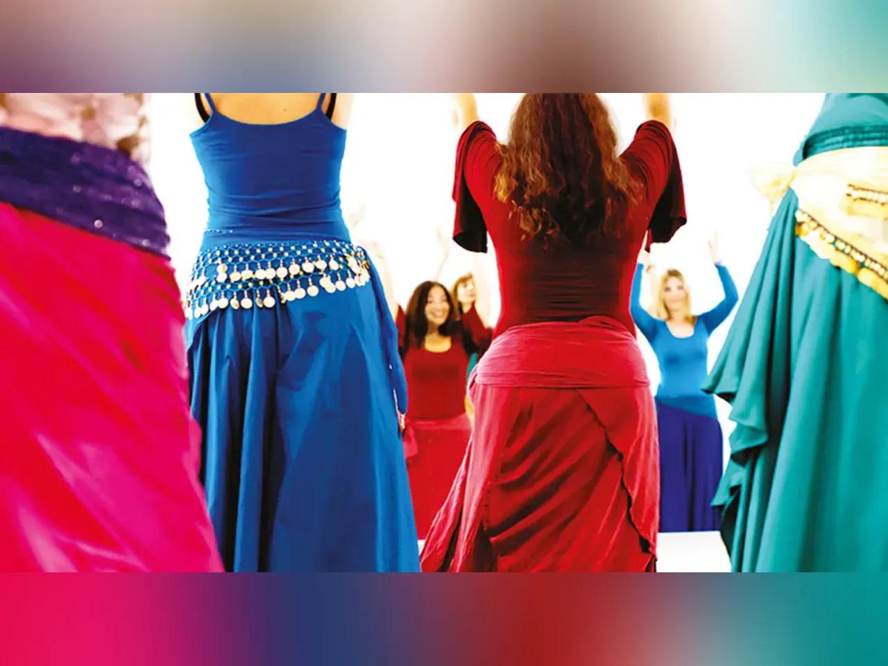 Frauen in bunten Kleidern machen Tanzbewegungen