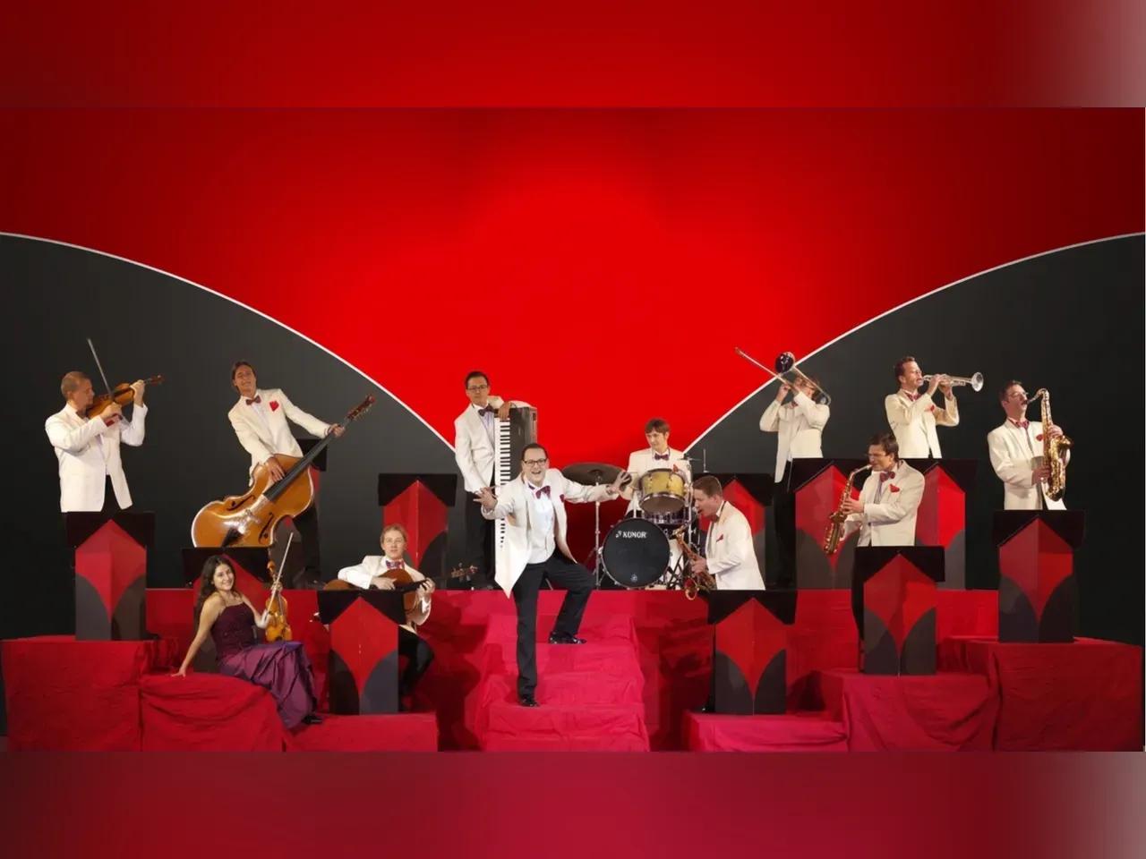 Die Musiker:innen des Ochesters in einem roten Studio