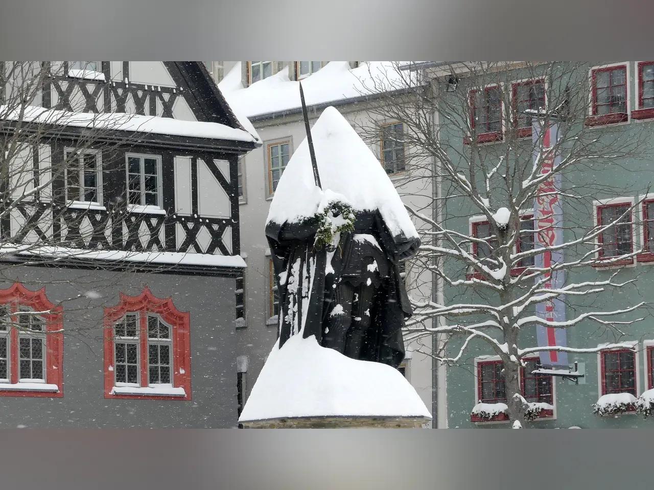 Mit Schnee bedeckte Hanfried-Statue auf dem Jenaer Marktplatz